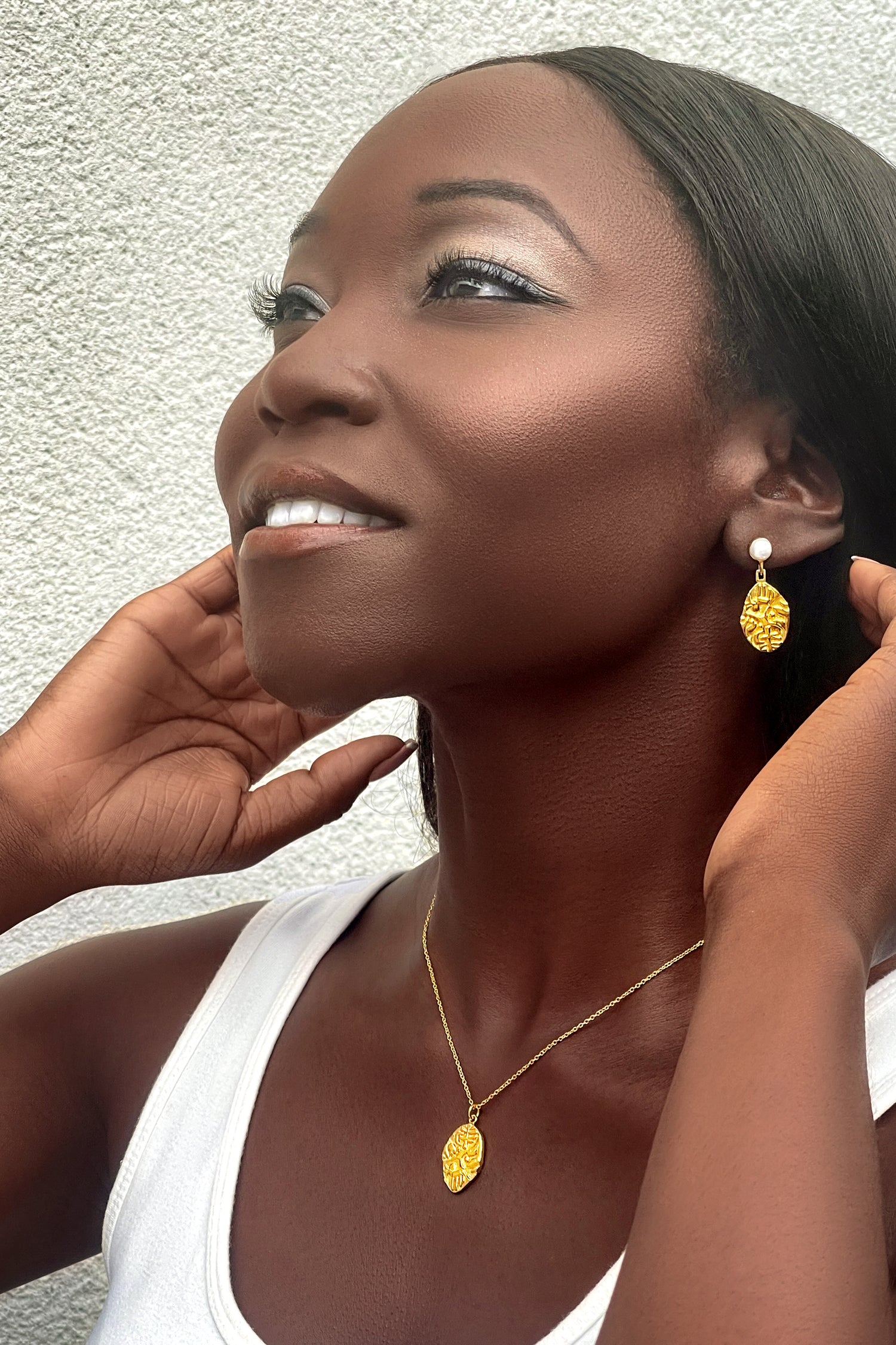 Model wearing the Sohavi Ancient Indian Coin Necklace with matching gold-coloured coin earrings and a white top.